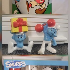 A Set Of Smurf glasses, 2 Figurines, And A soft Football